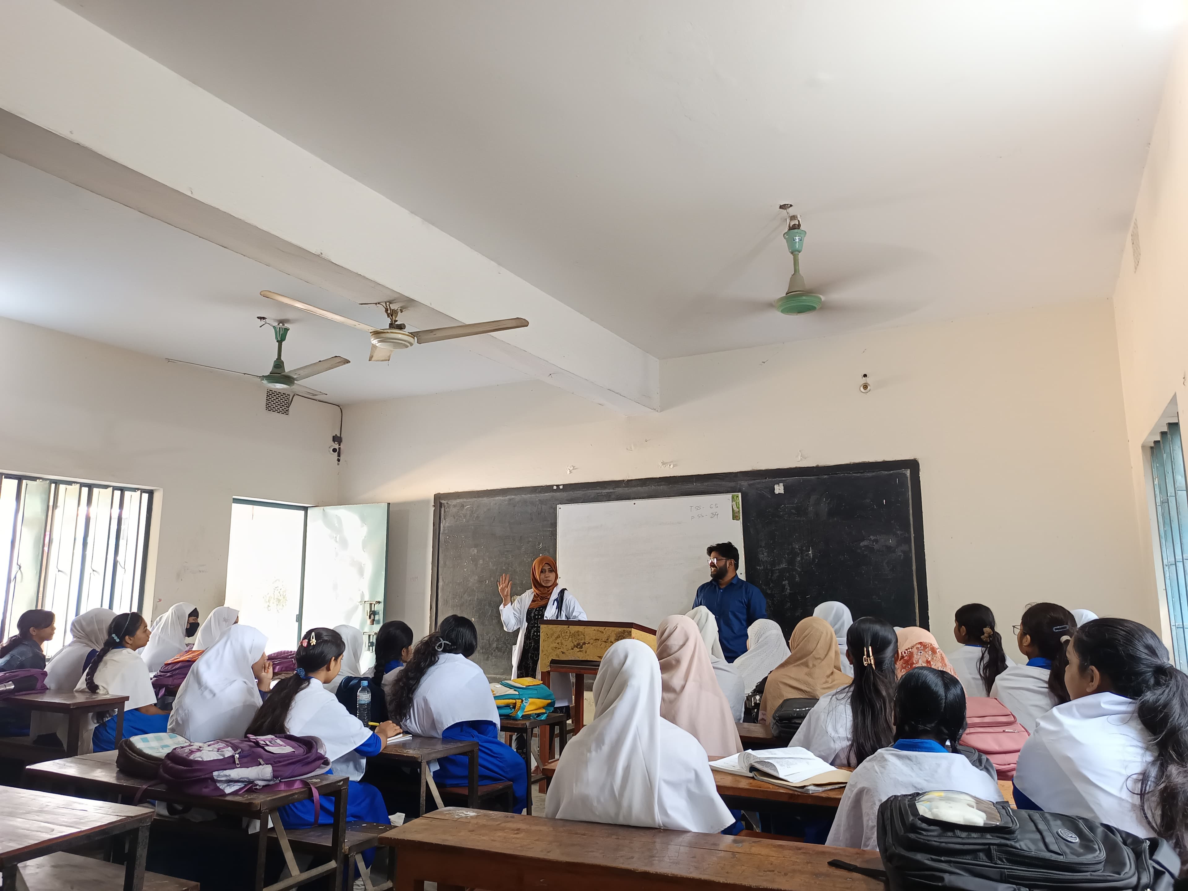 A volunteer leading a mental health session for a full classroom
